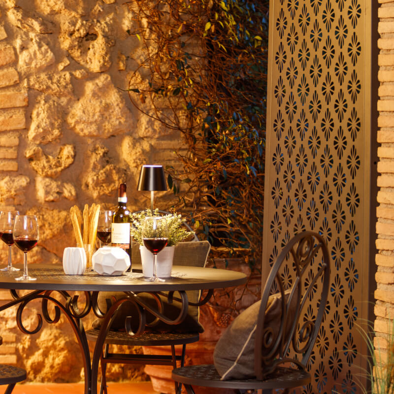 Metallsichtschutz Roya als Deko-Element hinter gemütlicher Sitzecke | Pulverbeschichtet anthrazit